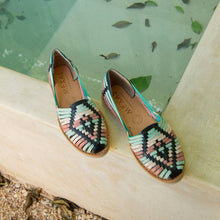 Load image into Gallery viewer, Pair of colorful woven shoes on a stone surface with a greenish background