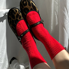 Load image into Gallery viewer, Red socks with black straps and leopard print shoes on a white background
