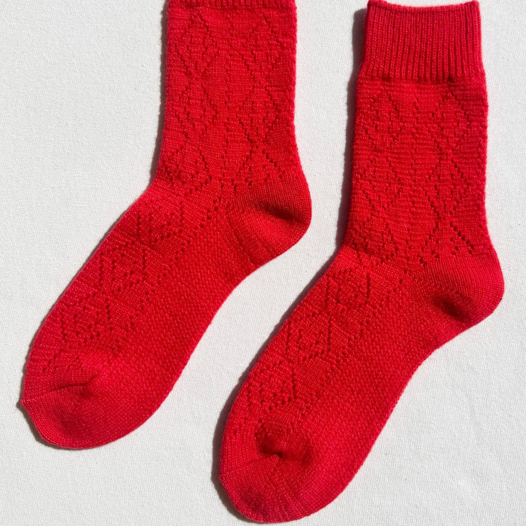 Pair of red socks on a light gray background